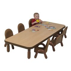 a little boy sitting at a table with some cards on it