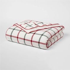 two blankets folded on top of each other in red and white plaid pattern, with one blanket folded over the edge