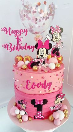 a minnie mouse birthday cake with balloons and confetti