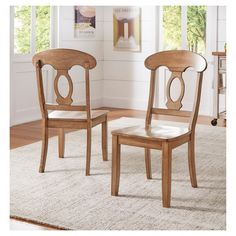 two wooden chairs sitting on top of a rug