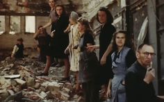 a group of people standing next to each other in front of a pile of rubble