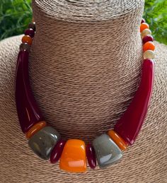 Make a statement with this lovely Maroon, Natural Grey & Mango orange bead feature Necklace.  Made with different shapes of resin beads, including round and long.  See separate listings for other colour options. The screw fastening is incorporated inside the resin beads.  This is a short necklace. Measures: Length: 47cm. Bead: 1 cm. Long bead: 8cm. LINKS for colour options:  https://thepeepaltree.etsy.com/uk/listing/1807259681/big-bead-necklace-red-crackle-beaded https://thepeepaltree.etsy.com/u Maroon Necklace, Red Mango, African Jewelry, Resin Beads, Brown Beige, Short Necklace, Bead Jewellery, Handmade Necklaces, Mango