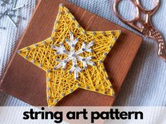 the string art pattern is made to look like a star on a piece of wood