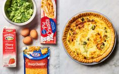 an assortment of food on a table including pizza, eggs, cheese and broccoli