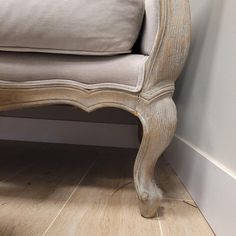 an old wooden bench sitting on top of a hard wood floor next to a wall