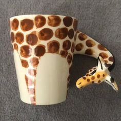 a ceramic giraffe head and cup on the floor