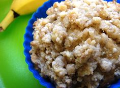 a blue bowl filled with oatmeal next to two bananas on a green plate