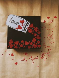 a box with hearts on it sitting on top of a piece of paper