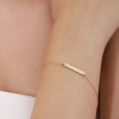 The handcrafted gold stacking bracelet features a slim bar pendant connected to a delicate cable chain, making it a versatile accessory suitable for both casual and formal occasions. It can be worn elegantly on its own or paired with any of our other beautiful bracelets. You'll receive: Handcrafted 18K Vermeil gold jewelry Jewelry sourced entirely from the USA Specifications: Material: 18K Vermeil Gold Cut: Excellent Dimensions: Height: 4 mm / 0.15 in Width: 12 mm / 0.47 in Chain Style: Cable Ch Bar Bracelet Personalized, Minimal Gold Jewelry, Gold Bar Bracelet, Gold Schmuck, Bar Bracelet, Gold Armband, Custom Bar, Gold Bracelet For Women, Bar Bracelets