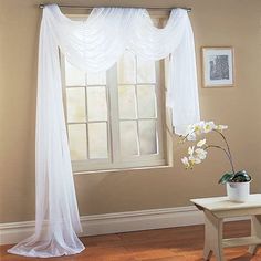 a living room with a window and white curtains