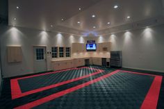 an empty room with black and red checkered flooring on the floor, television in the center