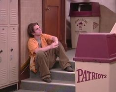 a man sitting on the steps in front of lockers