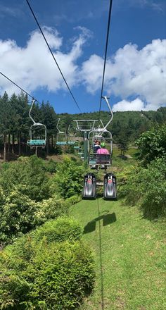 two people ride the gondola at an amusement park on a sunny day with blue skies and white clouds