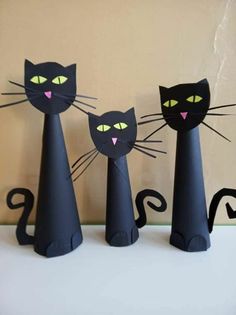 three black cats are standing next to each other