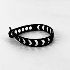 a black and white bracelet with an arrow on it