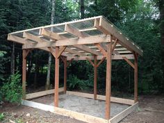 a wooden gazebo in the middle of a forest