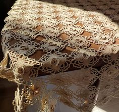 the table cloth has been made with lace and crochet, but it's not yet finished