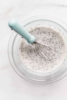 the ultimate guide to chia seeds in a glass bowl with a whisk