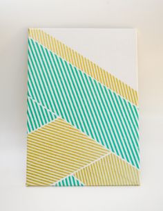 an abstract painting with yellow, blue and green stripes on white canvases against a plain background