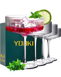 three wine glasses filled with different colored liquids and garnished with mint leaves