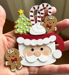 a hand holding a small christmas cup with gingerbreads