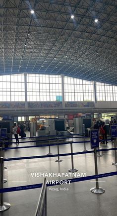 the inside of an airport with people waiting for their luggage