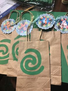 some brown paper bags with green designs on them and tags hanging from the top one