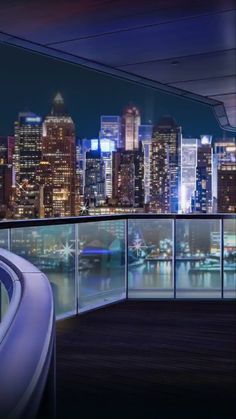 the city skyline is lit up at night as seen from an observation deck on a cruise ship