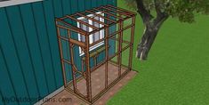 a small caged in bird house next to a tree