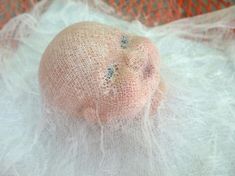 an infant doll is wrapped in white netting