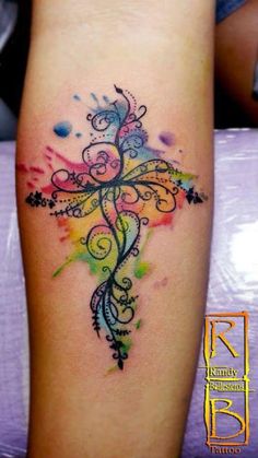 a colorful cross tattoo on the leg