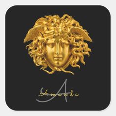 the golden head of an angel on a black square sticker, with gold lettering