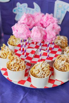 cupcakes with pink frosting and candy sticks in them