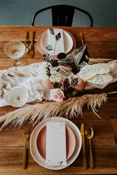 the table is set with plates, silverware and flowers