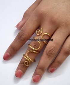 a woman's hand wearing a gold ring with two spirals on the middle