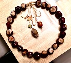 a wooden table topped with a necklace and an acorn on it's side