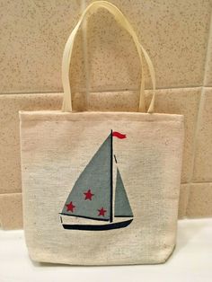 a bag with a sailboat on it is sitting on a counter next to a tile wall