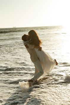 a man and woman are hugging on the beach