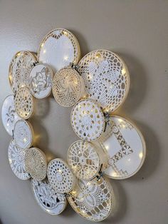 a wreath made out of plates with lights around it on the wall in front of a door