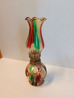 a colorful glass vase sitting on top of a table