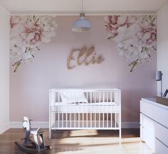 a baby's room with flowers on the wall