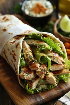 Grilled chicken wrap with lettuce on wooden board, with dipping sauce in the background. Caesar Salad Chicken Wrap, Healthy Nutritious Dinner, Meal Prep Wraps Healthy Recipes, Gourmet Lunch Recipes, Chicken Caesar Salad Wrap, Healthy Wraps Recipes, Healthy Wraps For Dinner, Chicken Wraps Recipes, Lunch Wrap Ideas