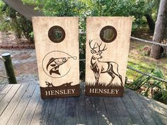 two cornhole game boards with an image of a deer and a fish on them