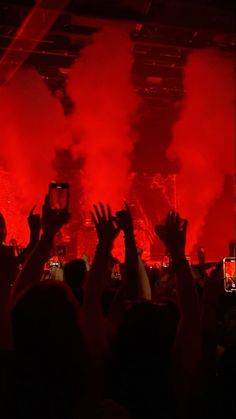 people are holding up their cell phones at a concert