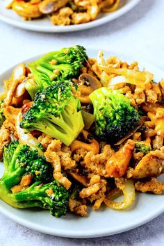 two white plates filled with stir fry and broccoli on top of each other