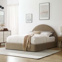 a bed sitting on top of a wooden floor next to a dresser