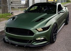 a green sports car parked on the side of the road