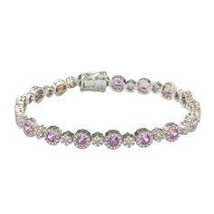 The timeless elegance of this tennis setting converges with rich pink sapphires to create a breathtakingly elegant design. Crafted in sterling silver, round-cut pink sapphires (5.44cttw) are prong set in a halo of created white sapphires (0.96cttw) with created white sapphire flower clusters connecting each sapphire (0.84cttw). 7.24cttw of glistering sapphires embezzle your wrist with this timeless, royal design. Finished with an SL logo and a Suzy Levian Secret Signature brown diamond in the ba Sl Logo, Levian Jewelry, Gemstone Brooch, Cubic Zirconia Bracelet, Cubic Zirconia Jewelry, Jewelry Rings Diamond, Brown Diamond, Gemstone Necklace Pendant, Pink Bracelet