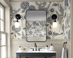 a bathroom with floral wallpaper and two sinks