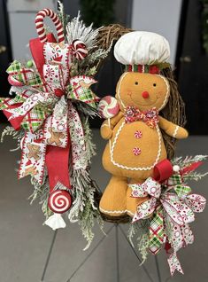 two gingerbread christmas wreaths with candy canes on the top and one holding a chef's hat